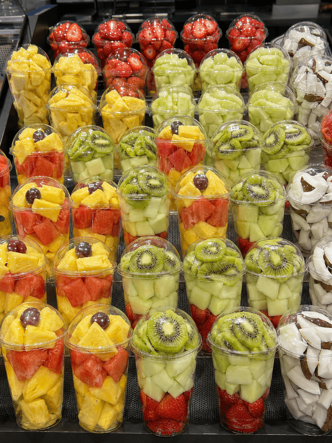 Vasos de fruta cortada envasada en expositor refrigerado